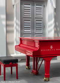 Red chairs on table by window in building