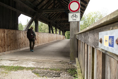 Rear view of woman walking on footpath