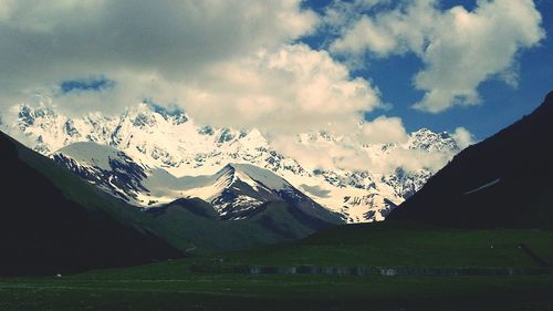 Scenic view of mountains against cloudy sky