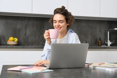 Young woman using laptop at table