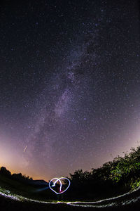 Low angle view of trees against sky at night