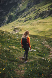 Rear view of woman walking on field