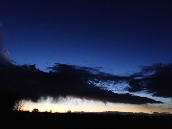 Silhouette trees on field against clear sky at night