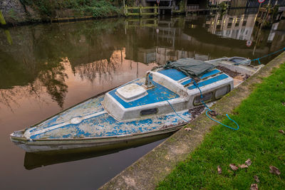 Part sunken broads cruiser tied to the bank of the river wensum in the city of norwich