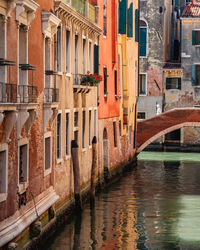 Colorful buildings and a woman walking across a bridge over a canal in venice, italy