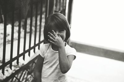 Portrait of boy standing on railing