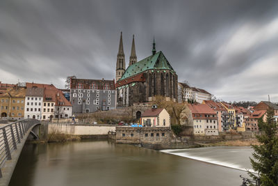 View of buildings in city against cloudy sky