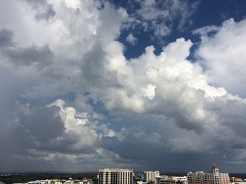 Buildings in city against dramatic sky