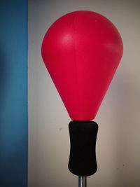 Close-up of red balloon against blue wall