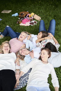 Happy group of women lying on a blanket in a meadow