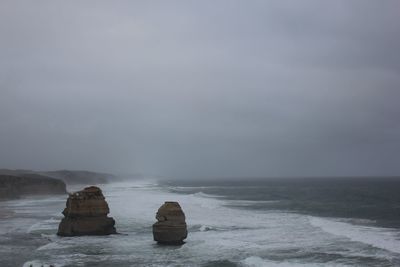 Rocks on sea shore against sky