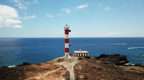 High angle view of lighthouse on beach against sky during sunny day
