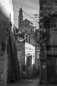 Alley amidst buildings and church at town