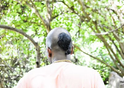 Rear view of man against tree