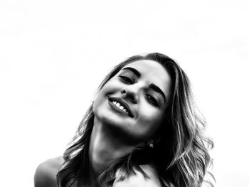 Portrait of smiling young woman against white background
