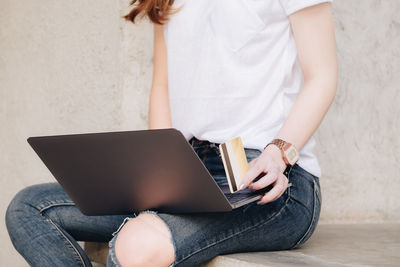Midsection of woman using mobile phone