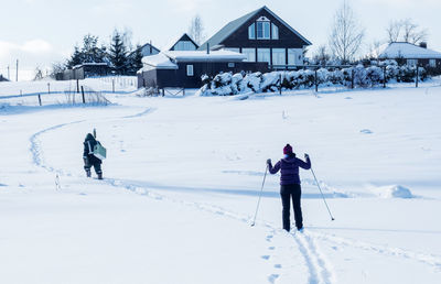 Rear view of people on snow covered field