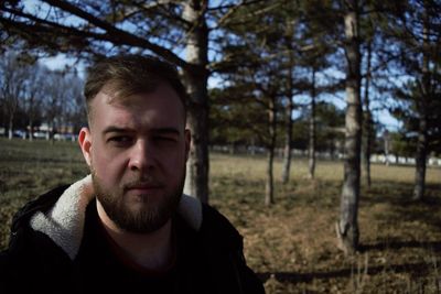 Portrait of young man against trees