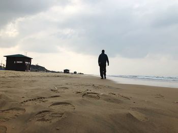 Rear view of a man walking on beach