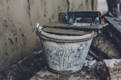 Cement covered bucket and trowel at construction site