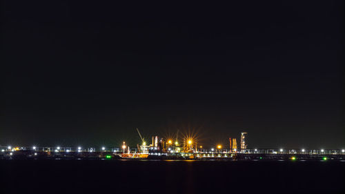 Oil ship tanker loading oil at the oil brige on the sea from refinery for transportation at night 