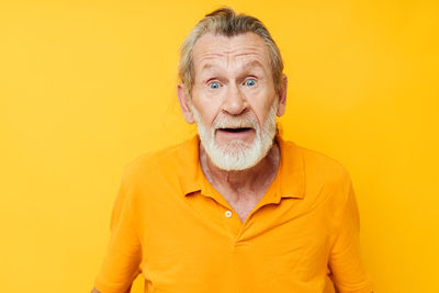 Portrait of young man against yellow background