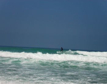 Man surfing in sea against sky