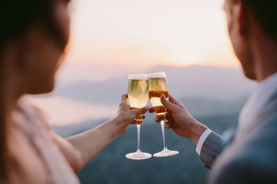 Rear view of people drinking beer at sunset