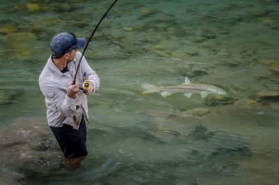 High angle view of man fishing in river