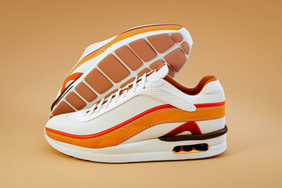 Close-up of shoes on floor against orange background