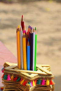 Close-up of multi colored pencils on sand