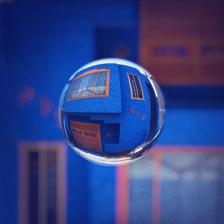 focus on foreground, close-up, reflection, glass - material, transparent, blue, transportation, circle, illuminated, communication, window, no people, building exterior, indoors, sphere, built structure, architecture, selective focus, day