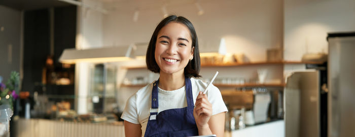 Portrait of young woman standing at home