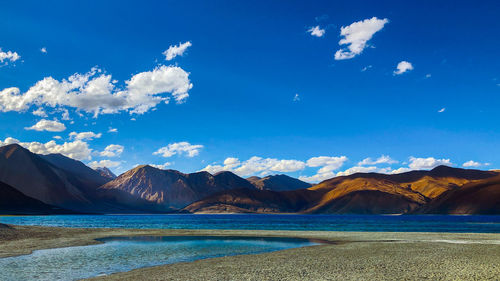 Scenic view of mountains against blue sky