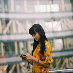 Young woman using mobile phone at camera