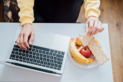 Freelancer young woman eating healthy food when working from home. woman eating healthy grain