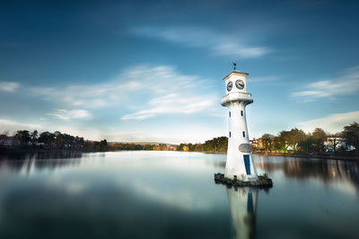 Reflection of tower on lake against sky