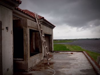 Built structure by sea against sky