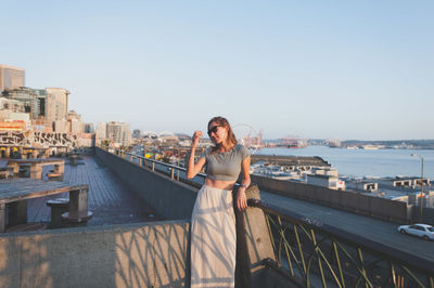 Young woman standing at building terrace in city