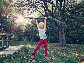 Portrait of girl holding wood in park