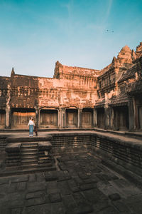 Full length of woman standing at ancient temple against sky