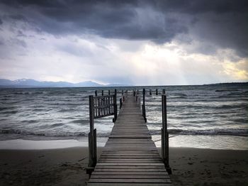 Wooden pier on sea shore against sky