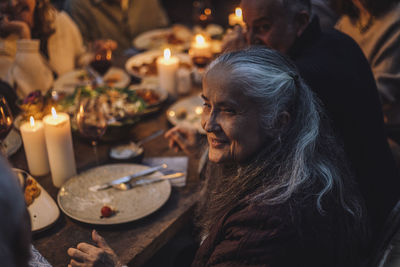 Smiling senior woman looking away during dinner party