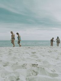 People on beach against sky