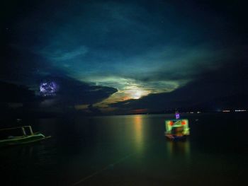 Scenic view of lake against sky at night