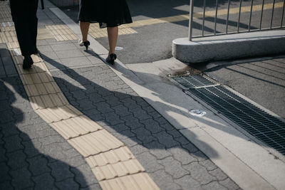 Low section of people walking on footpath