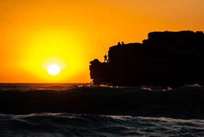 Scenic view of sea against orange sky