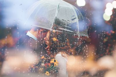 Portrait of woman on wet glass during rainy season