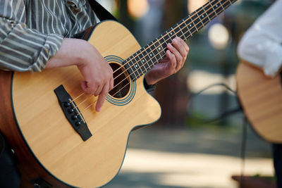 Midsection of man playing guitar