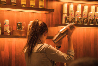 Side view of young woman standing at restaurant